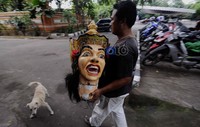 Seorang pekerja membawa kepala ogoh-ogoh untuk dipasangkan ke badannya.