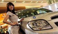 Seorang model berpose dengan MPV Orlando.