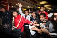 Pemain ganda campuran Lilyana Natsir (depan) dan Tontowi Ahmad (belakang) dikerumuni para fans yang menamakan Badminton Lovers di terminal 2D, Bandara Soekarno-Hatta, Jakarta.