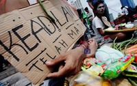 Seorang demonstran membawa kardus bertuliskan keadilan telah mati