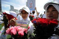 Dalam aksinya mereka membawa bunga mawar beraneka warna.