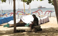 Seorang pecalang berkomunikasi menggunakan ponsel ketika menjaga objek wisata Pantai Sanur. ANTARA/M. Irfan Ilmie.