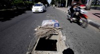 Kendaraan melintas diantara jalan berlubang akibat penutup gorong-gorong yang hilang di Jalan Sudirman, Jakarta.