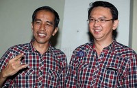 Jokowi memperlihatkan tangannya dengan gaya metal saat didampingi calon wakilnya Ahok (kanan), di Jakarta.