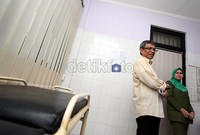 Didik J Rachbini (kiri), didampingi Dr Seri (kanan), dokter dari Puskesmas Kelurahan Bendungan Hilir, Jakarta, melihat-lihat ruangan pemeriksaan kesehatan pasien.