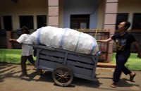 Petugas kebersihan sedang menimbang sampah warga yang akan ditabung pada bank sampah di Menteng Jaya, Jakarta