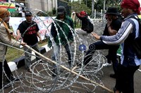 Para pendemo menerobos kawat berduri yang dipasang di depan gerbang gedung DPR, Jakarta. Ramses/detikcom.