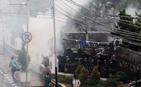 Berkali-kali gas air mata mampir ke balik pagar, namun para prajurit tersebut tetap dengan posisinya.