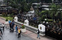 Tentara hanya menonton dari balik pagar menggunakan pentungan lengkap tameng dan masker.