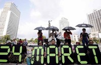 Para demonstran membentangkan spanduk hitam yang bertuliskan HAM dengan lambang dicoret di bawah mereka