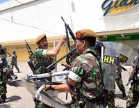 Anggota TNI Angkatan Darat melepaskan tembakan peringatan saat massa melempari mereka batu.