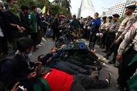 Sebagian mahasiswa melakukan aksi tidur di badan jalan yang diawasi dan dijaga oleh aparat kepolisisan.