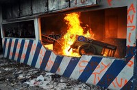 Massa memasukkan gerobak kayu ke dalam pos polisi yang sudah mulai dilalap api.