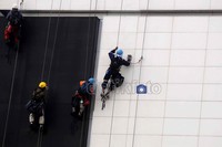 Dengan pengaman seadanya para pekerja membersihkan dinding gedung sebuah pusat perbelanjaan di Jakarta.