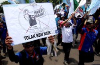 Para buruh membawa poster penolakan kenaikan harga BBM serta bendera organisasi masing-masing.