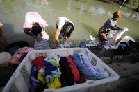 Pakaian yang telah dicuci diletakkan di keranjang dan ember yang mereka bawa. Warga di bantaran Sungai Selapajang tidak menghiraukan penyakit yang ditimbulkan akibat mencuci di sungai tersebut.