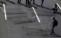 Para buruh memblokir jalan tol di depan gedung DPR dengan menggunakan pagar.