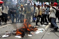 Para pendemo mengitari topeng SBY yang dibakar sambil meneriakkan yel-yel penolakan kenaikan harga BBM.