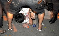 Seorang pria tergeletak tak berdaya akibat dikeroyok oleh polisi dan warga.