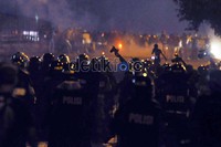 Polisi melepaskan tembakan gas air mata.