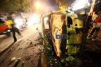 Bangkai mobil yang dibakar massa teronggok di kawasan Salemba.