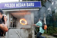 Massa menyulutkan ban bekas yang telah dibakar ke dalam Pos Polisi, di persimpangan Jalan Sudirman-S Parman, Medan, Sumut. ANTARA/Irsan Mulyadi.