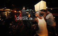 Ojek gerobak dadakan jadi alat menyeberang para pemotor untuk menghindari banjir.