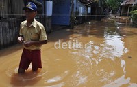 Warga setempat tampak telah biasa dengan banjir yang meremdam rumah mereka.