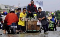 Ketinggian air yang merendam jalan memaksa mereka menggunakan jasa dadakan ini.