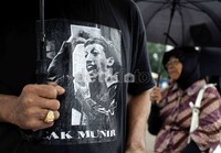 Dalam aksi tersebut, salah satu peserta aksi mengenakan kaos bergambar Munir.