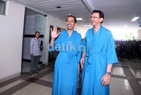 Dengan mengenakan piyama, pasangan Jokowi-Ahok menyapa wartawan sebelum menjalani tes kesehatan.