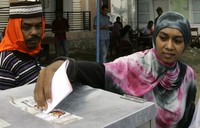 Seorang warga Aceh Besar memasukan kertas suara ke kotak suara. REUTERS/Junaidi Hanafiah.