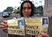 Suryantinah menunjukkan kartu pendaftaran anaknya.