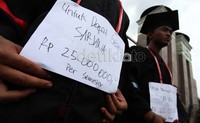 Dalam aksinya mereka juga menggunakan atribut pakaian wisuda.