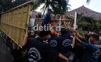 Barang-barang dari rumah tersebut dikeluarkan kemudian diangkut dengan truk.