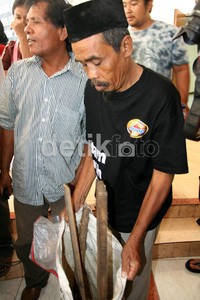 Seorang warga menunjukan barang bukti berupa kayu, besi dan batu yang digunakan untuk melukai warga. Ramses/detikcom.
