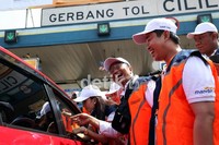 Artika Sari Dewi (kiri) dan Direktur Utama  Mandiri Zulkifli Zaini (kanan) turut menawarkan e-Toll Card bersama Dahlan Iskan di pintu gerbang tol Cililitan, Jakarta.