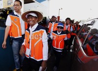 Dahlan Iskan dengan memakai caping berjalan menuju pintu gerbang Cililitan untuk menawarkan penggunaan e-Toll Card.