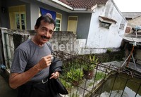 Jhony Indo melewati gang, saat keluar dari rumah kontrakan di daerah Cimelati, Sukabumi, Jawa Barat, Selasa (17/4/2012). Kini, Jhony Indo juga telah membentuk Yayasan Jhony Indo Foundation untuk membantu anak-anak yang kurang mampu dalam bidang pendidikan, keagamaan, dan sosial.