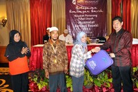 Direktur Keuangan dan Operasional Bank Muamalat, Hendiarto menyerahkan perlengkapan Umroh secara simbolis kepada nasabah Bank Muamalat. (Dok Muamalat).