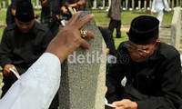 Tangan Habibie tak lepas-lepasnya memegang batu nisan istrinya.