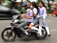 Tiga siswa yang berboncengan tanpa menggunakan helm pengaman mengabaikan keselamatan nyawanya sendiri.