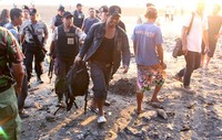 Polisi mengamankan tas yang tergeletak di dekat tempat sampah pantai Seminyak. (Wiyudha Ari Shandy).