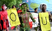 Salah seorang mahasiswa peserta aksi mewarnai dan melilitkan tumbuhan di badannya.