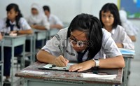 Seorang siswi SMP Negeri 6 Makassar tampak serius mengisi lembar jawaban UN.