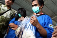Tersangka Pipit Setiawan (kanan) memegang barang bukti Narkotika  berupa ekstasi dan sabu di lokasi pemusnahan Badan Narkotika Nasional (BNN), Jakarta.