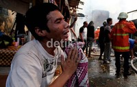 Sejumlah orang menangis meratapi rumah miliknya yang ludes terbakar.