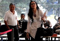 Sepanjang menuju pintu masuk KPK, Angie menebar senyum. Namun tidak ada pertanyaan wartawan yang dijawab janda