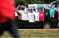 Seorang pengunjung melintas di depan pedagang yang menjual aksesoris SuJu.