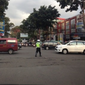 Saat Mengatur Lalu Lintas, Polisi Malah Asik SMS-an